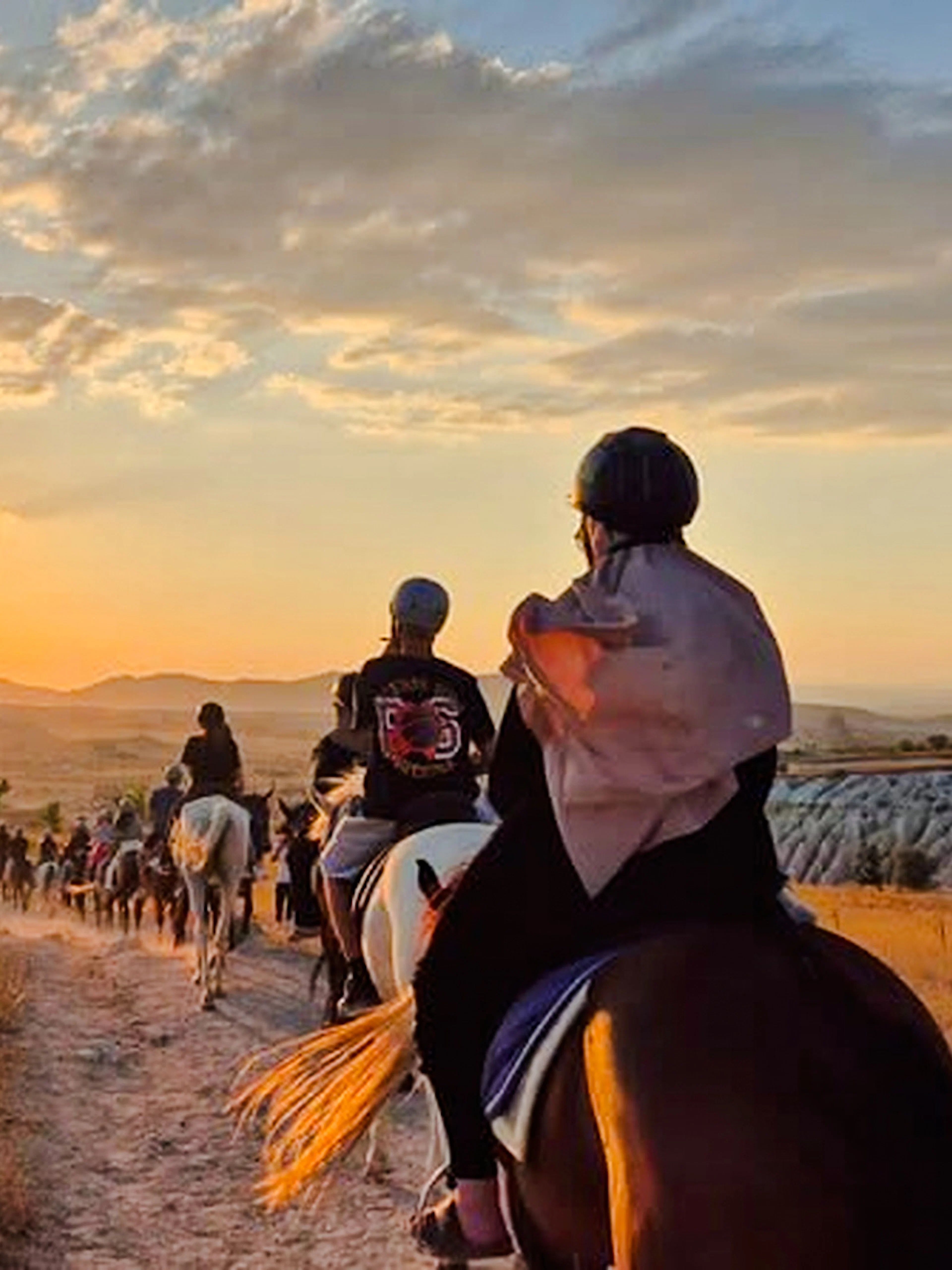 Horseback riders on a trail at sunrise in Cappadocia, Turkey.