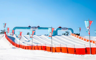 Snow tubing lanes at Vivaldi Park Snowy Land, South Korea, with colorful flags.