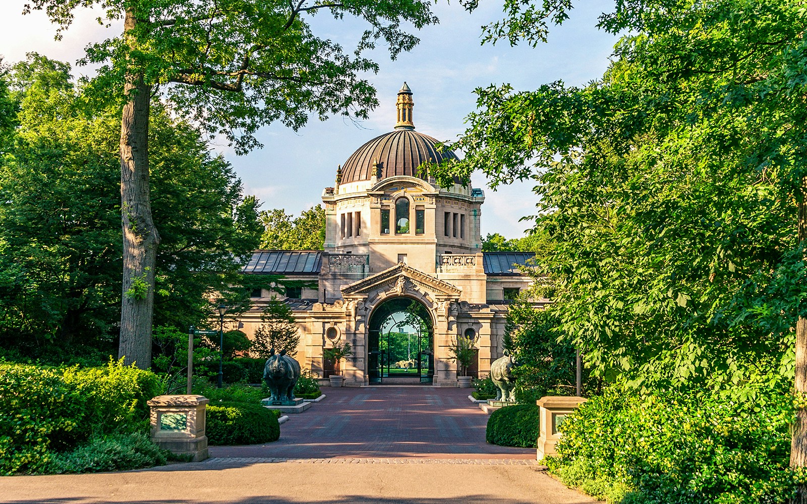 Entrance to the Bronx Zoo with historic architecture and lush greenery.