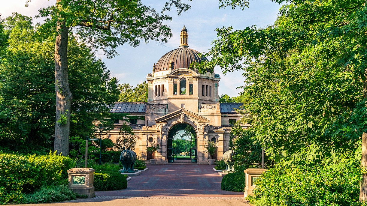 Entrance to the Bronx Zoo with historic architecture and lush greenery.