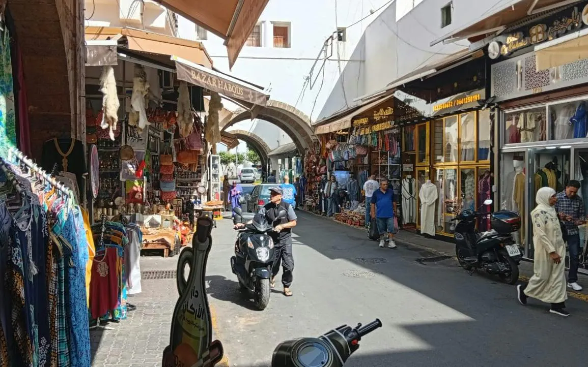 Bustling market street in Marrakech with shops and people, part of Casablanca day trip.
