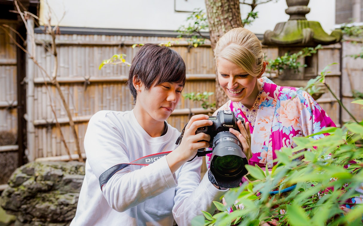 Photographer showing camera to woman in kimono at Kyoto Kimono Rental Yumeyakata.