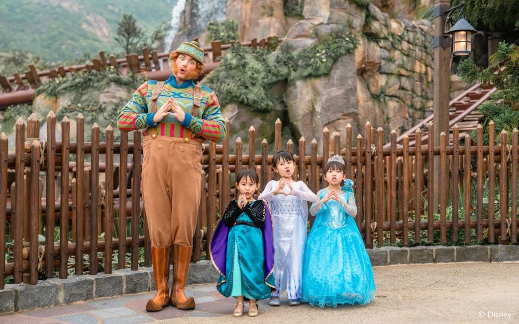 Girls in Frozen costumes with character at Disneyland Hong Kong.