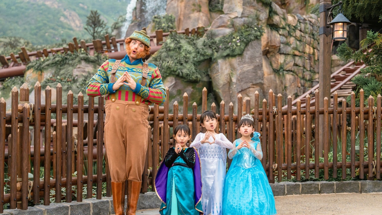 Girls in Frozen costumes with character at Disneyland Hong Kong.