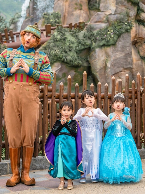 Girls in Frozen costumes with character at Disneyland Hong Kong.