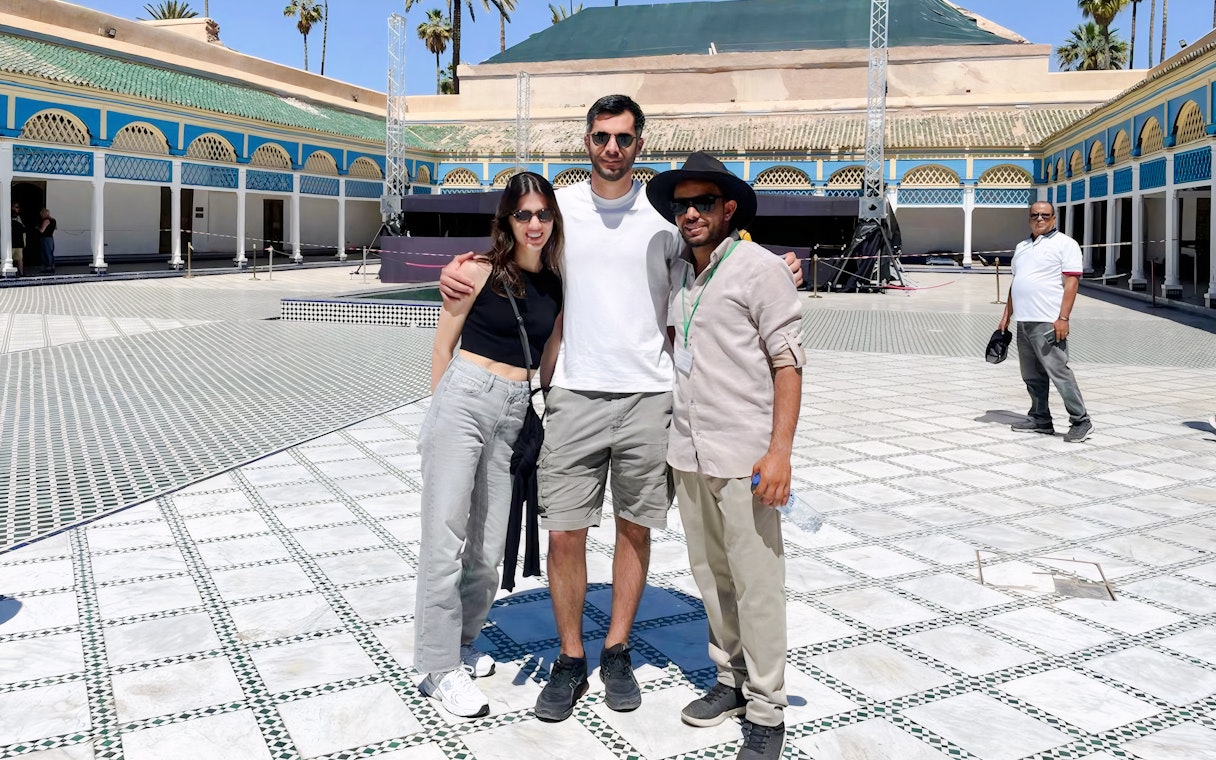 Tourists with a guide at Bahia Palace courtyard in Marrakech.