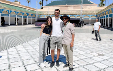 Tourists with a guide at Bahia Palace courtyard in Marrakech.