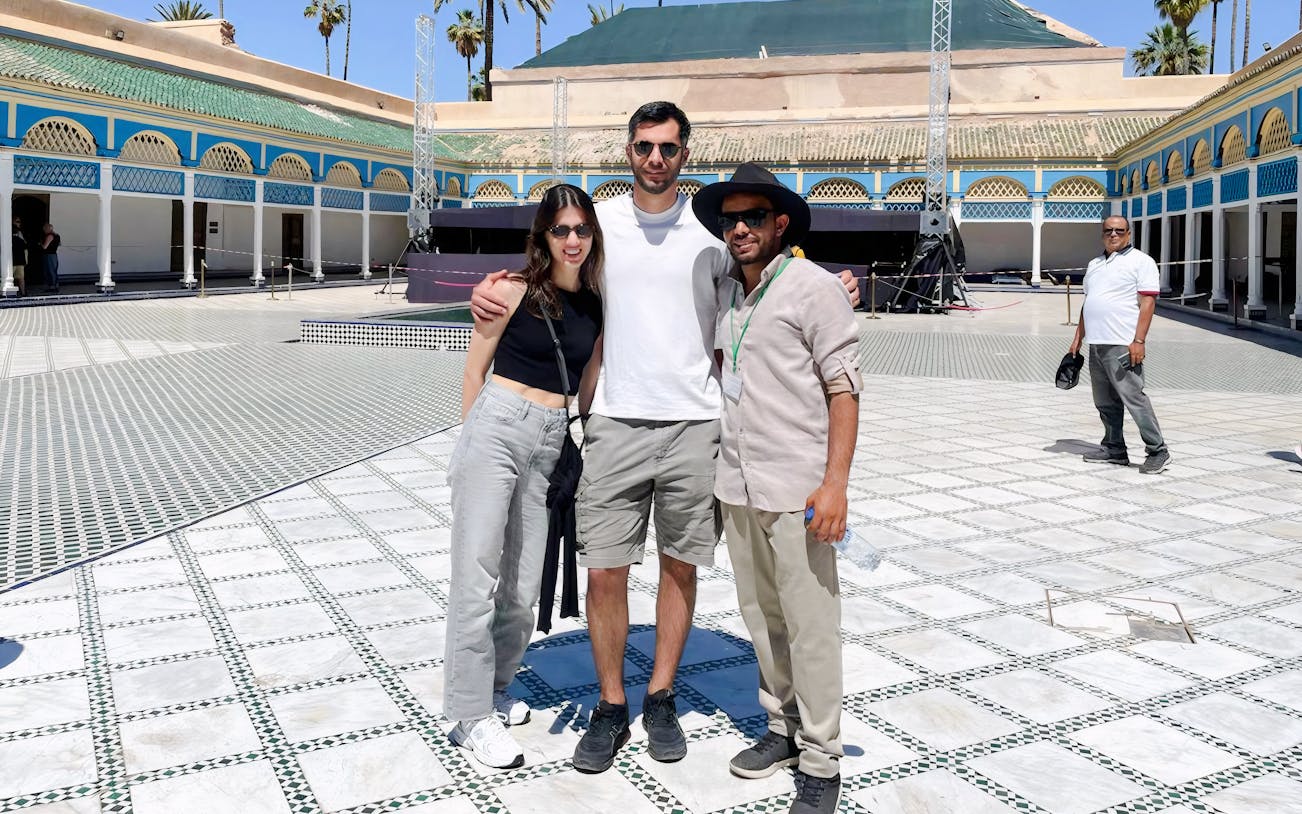 Tourists with a guide at Bahia Palace courtyard in Marrakech.