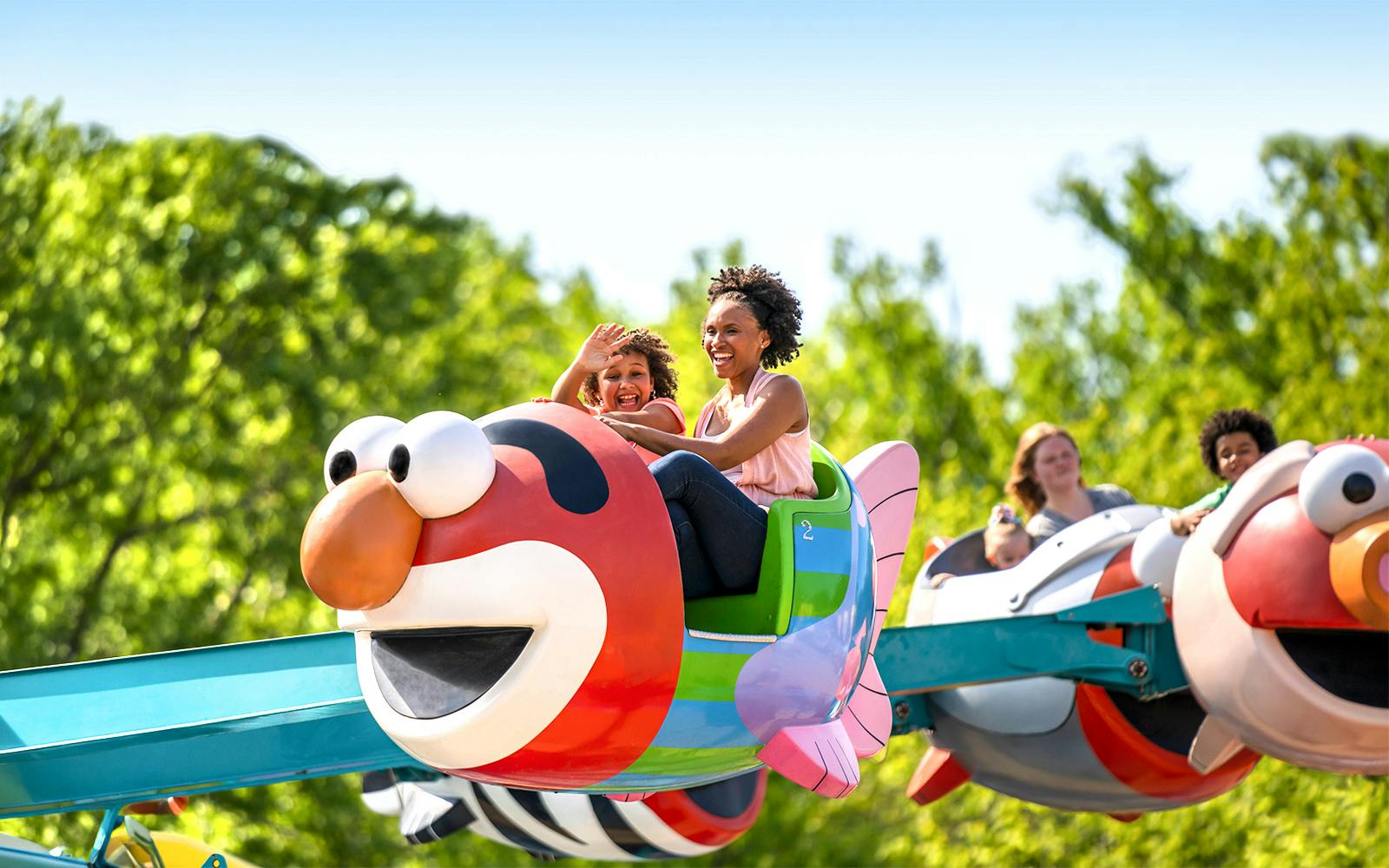 Families enjoying Elmo-themed ride at Sesame Place Philadelphia.