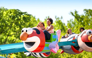 Families enjoying Elmo-themed ride at Sesame Place Philadelphia.