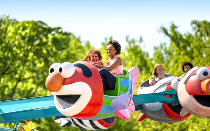 Families enjoying Elmo-themed ride at Sesame Place Philadelphia.