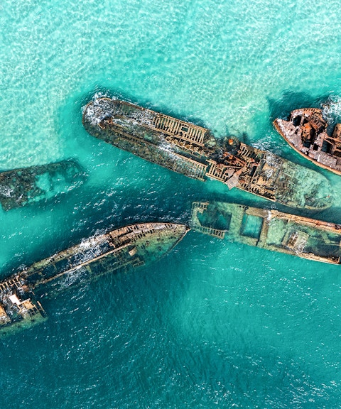 Aerial view of shipwrecks in turquoise waters at Moreton Island, Australia.