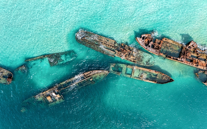 Aerial view of shipwrecks in turquoise waters at Moreton Island, Australia.