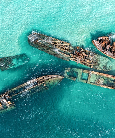 Aerial view of shipwrecks in turquoise waters at Moreton Island, Australia.