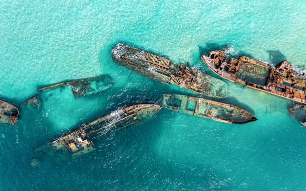 Aerial view of shipwrecks in turquoise waters at Moreton Island, Australia.
