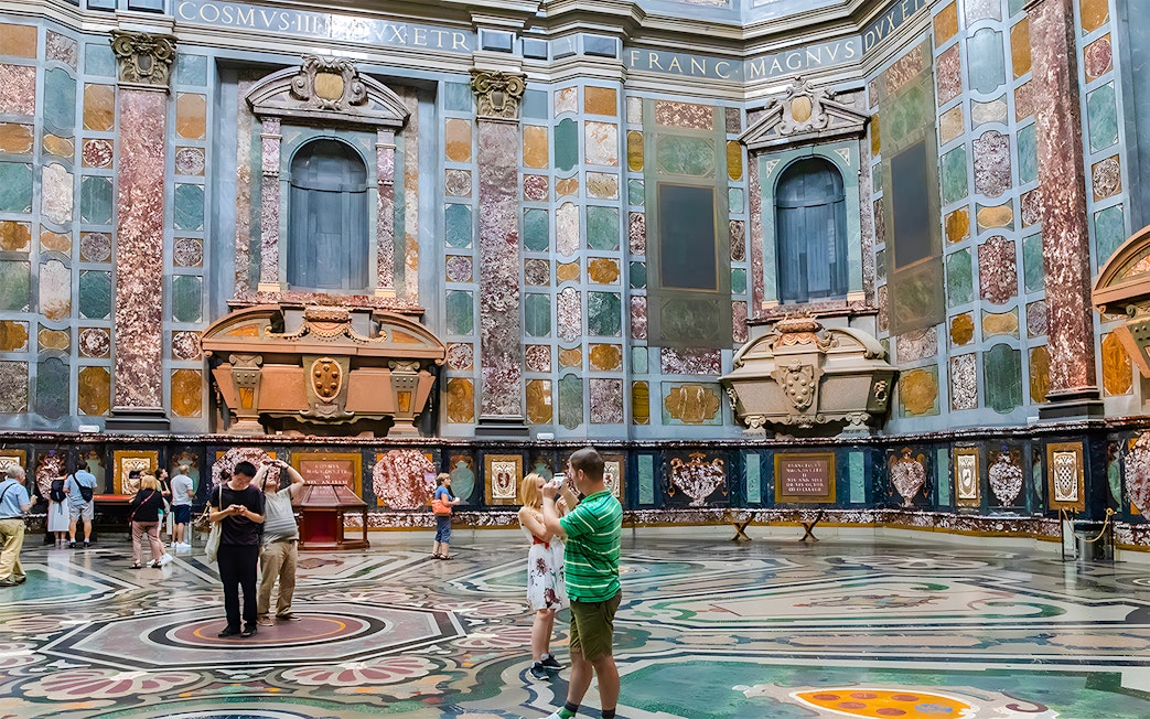 Visitors exploring the ornate interior of the Medici Chapels in Florence, Italy.