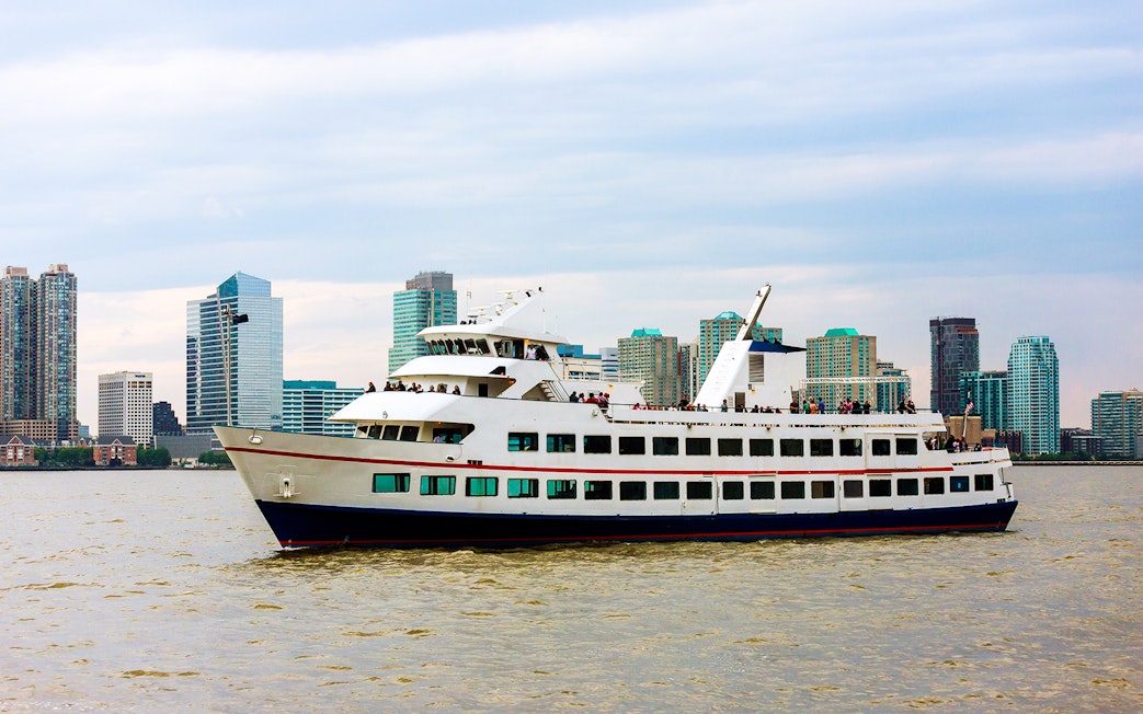 Cruise ship sailing near Manhattan skyline on Circle Line tour, New York City.