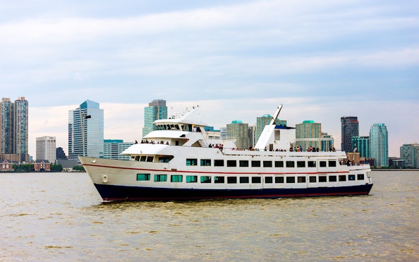 Cruise ship sailing near Manhattan skyline on Circle Line tour, New York City.