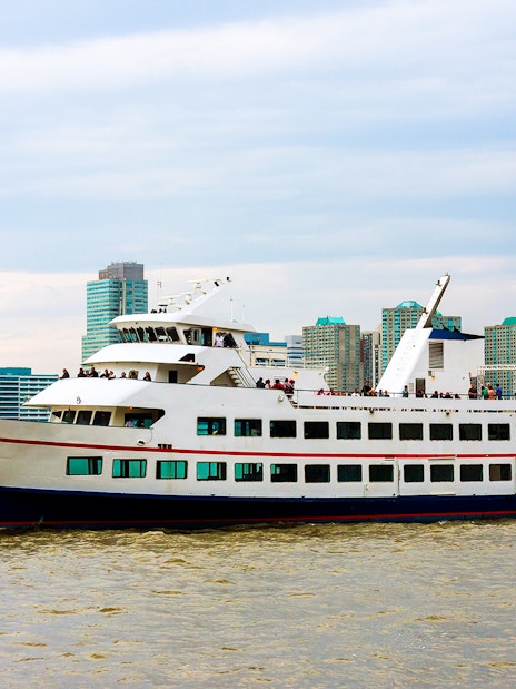 Cruise ship sailing near Manhattan skyline on Circle Line tour, New York City.