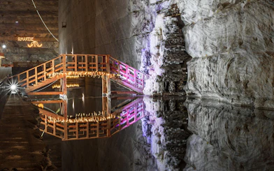 Wooden bridge with lights over water in Slanic Prahova Salt Mine, Bucharest.