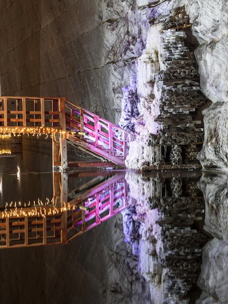 Wooden bridge with lights over water in Slanic Prahova Salt Mine, Bucharest.