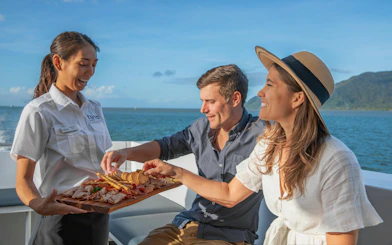 Couple enjoying snacks on a boat during a Great Barrier Reef snorkeling tour from Cairns.