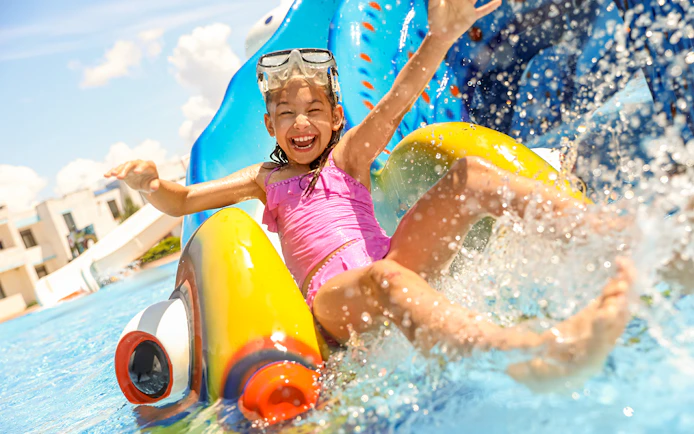 Child enjoying a water slide at Yas Waterworld Abu Dhabi.