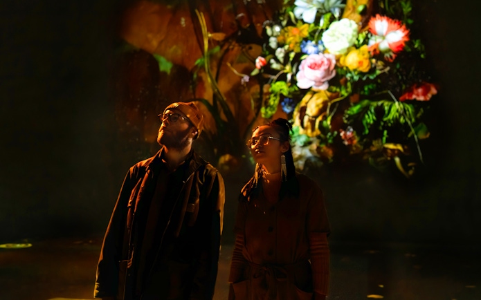 Visitors viewing digital floral art at Frameless London exhibition.