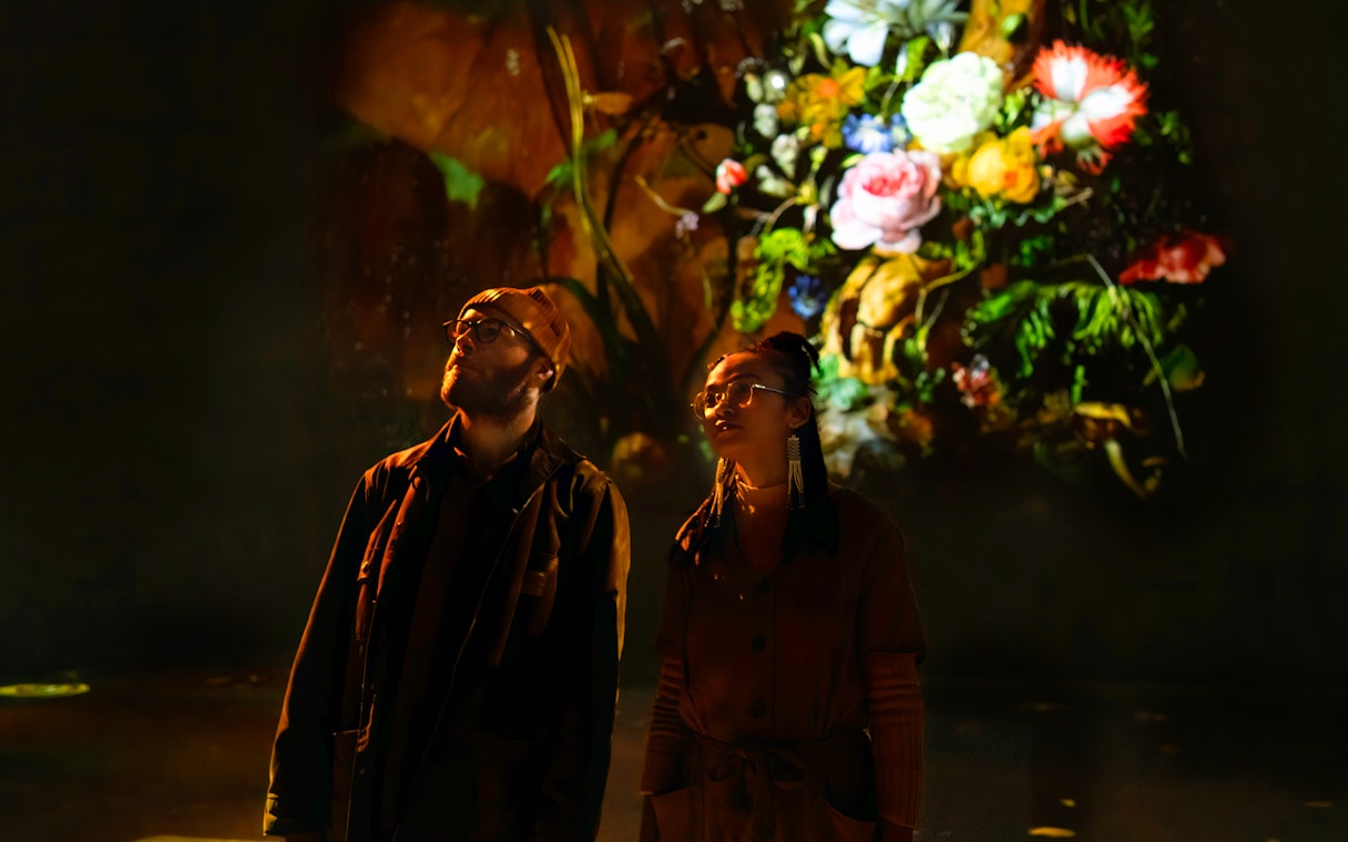 Visitors viewing digital floral art at Frameless London exhibition.