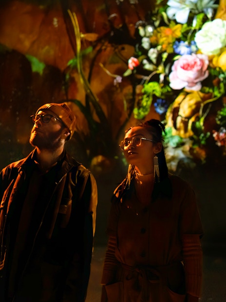 Visitors viewing digital floral art at Frameless London exhibition.