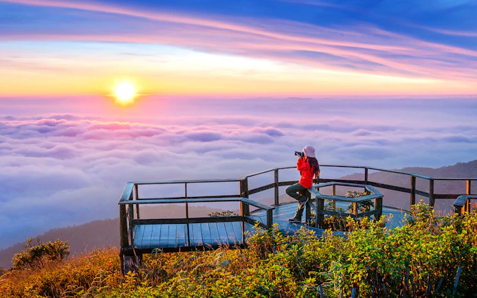 Tourist photographing sunset at Kew Mae Pan viewpoint, Doi Inthanon, Chiang Mai, Thailand.