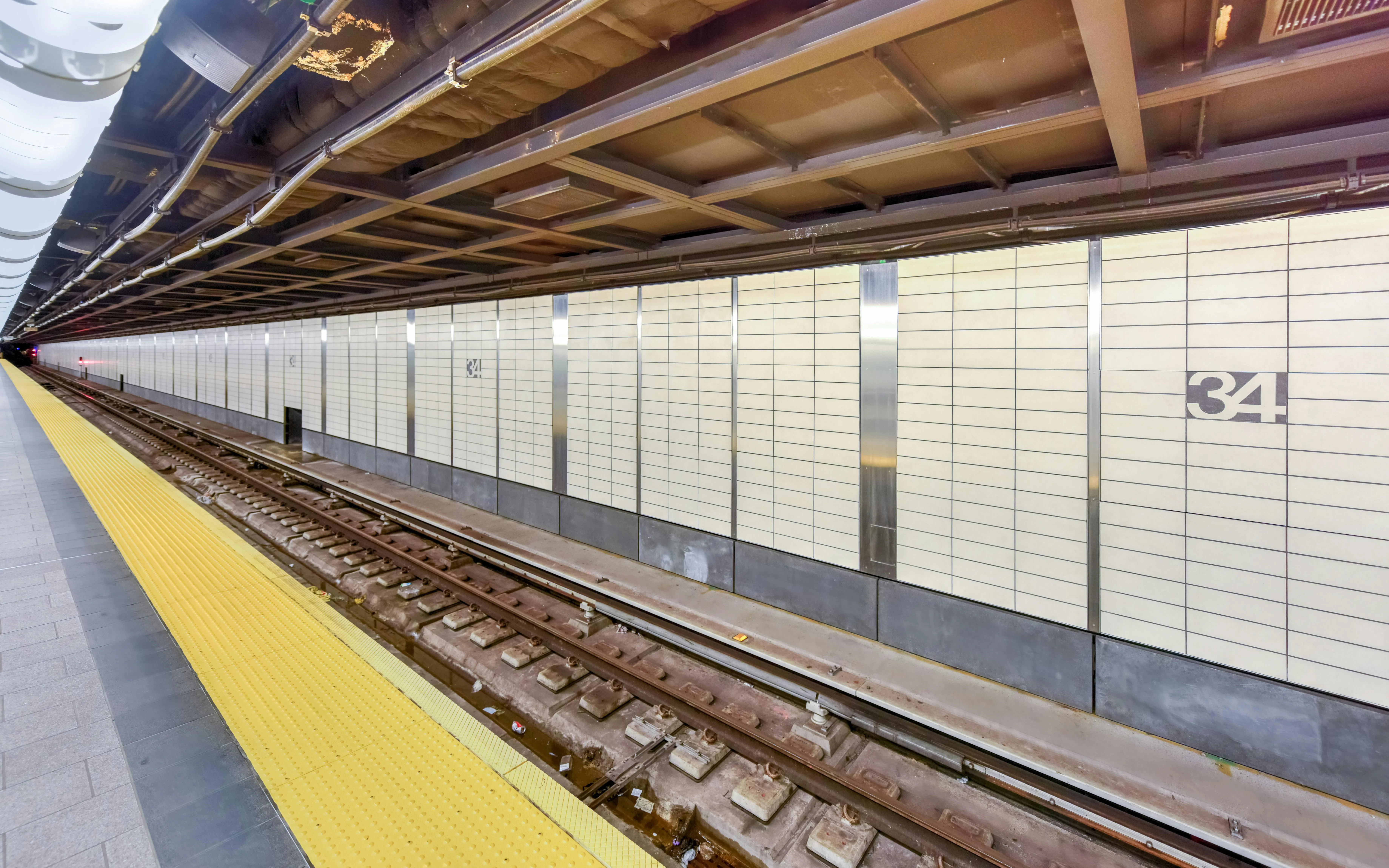 Hudson Yards Subway Station platform in Chelsea, NYC, with tracks and tiled walls.