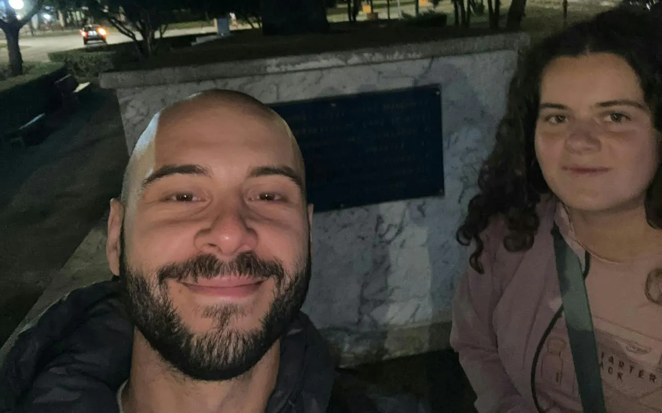 Two people in front of a monument related to the Brașov Workers' Protest, Brasov.