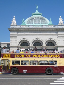 Big Bus Philadelphia tour passing by a historic building with a domed roof.
