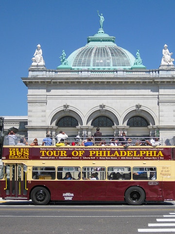 Big Bus Philadelphia tour passing by a historic building with a domed roof.