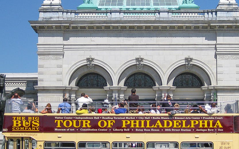Big Bus Philadelphia tour passing by a historic building with a domed roof.