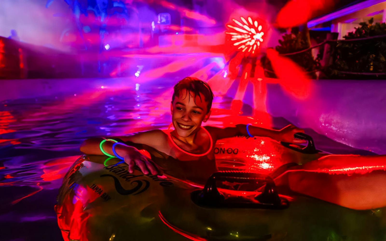 Child enjoying a glowing tube ride at AquaGlow, Adventure Island Tampa.