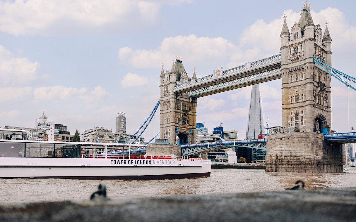 Cruise boat on the Thames passing Tower Bridge in London.