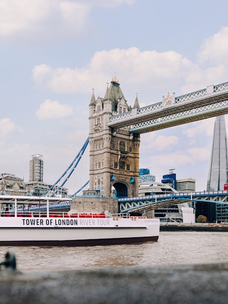 Cruise boat on the Thames passing Tower Bridge in London.
