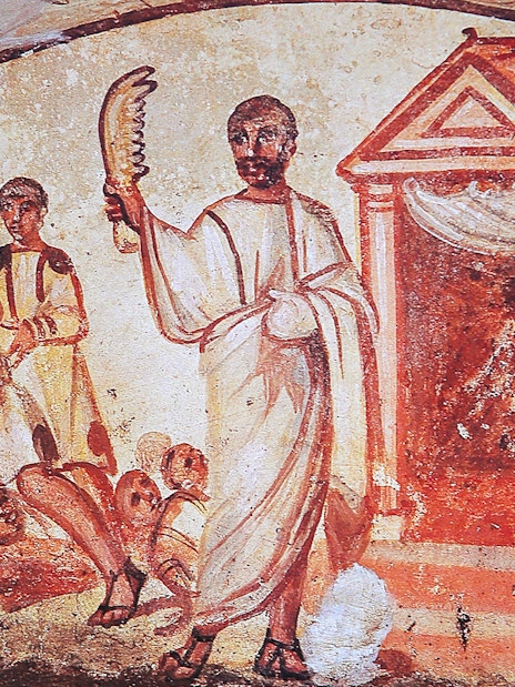 Ancient fresco depicting figures in Roman attire inside catacombs on the Appian Way, Rome.