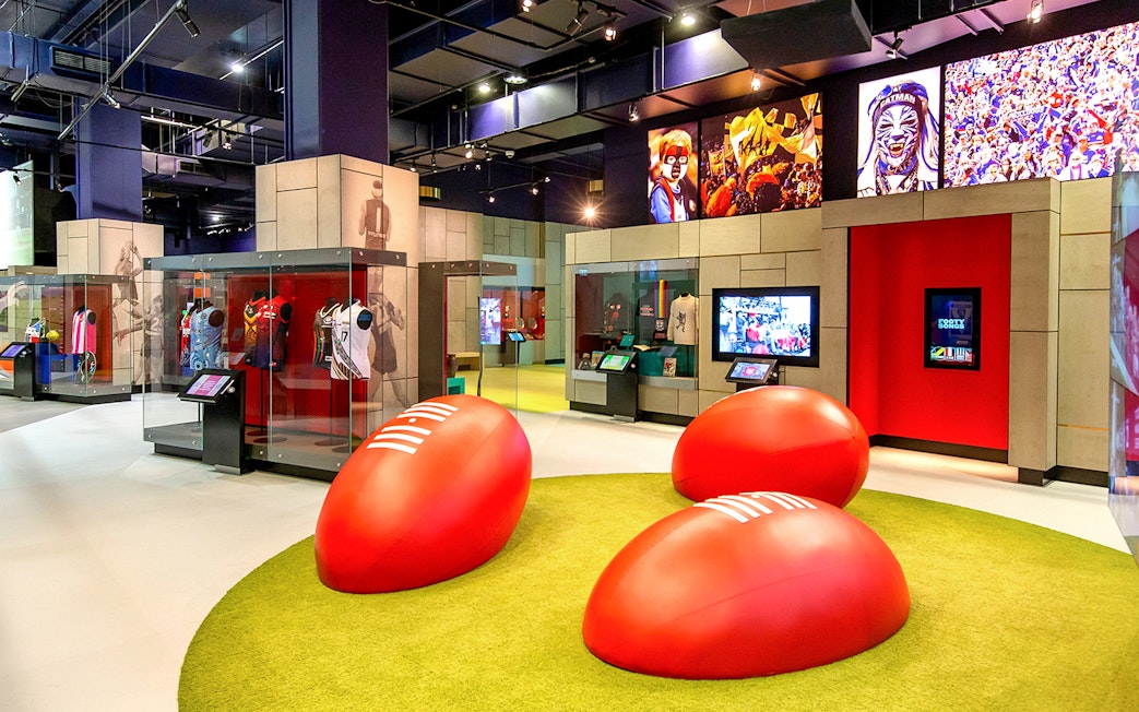 MCG sports museum exhibit with jerseys and interactive displays.