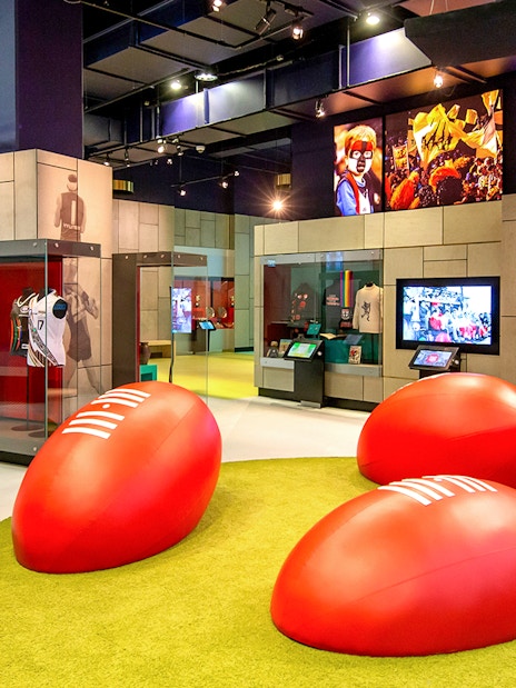 MCG sports museum exhibit with jerseys and interactive displays.