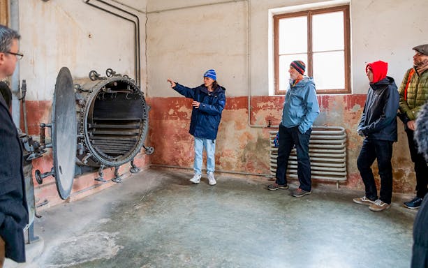 Guide explaining historical details to tourists at Terezin Concentration Camp.