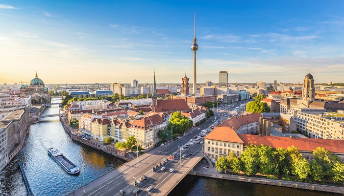 Schiff auf der Spree, grüne Bäume, Berliner Innenstadt und Fernsehturm in Hintergrund