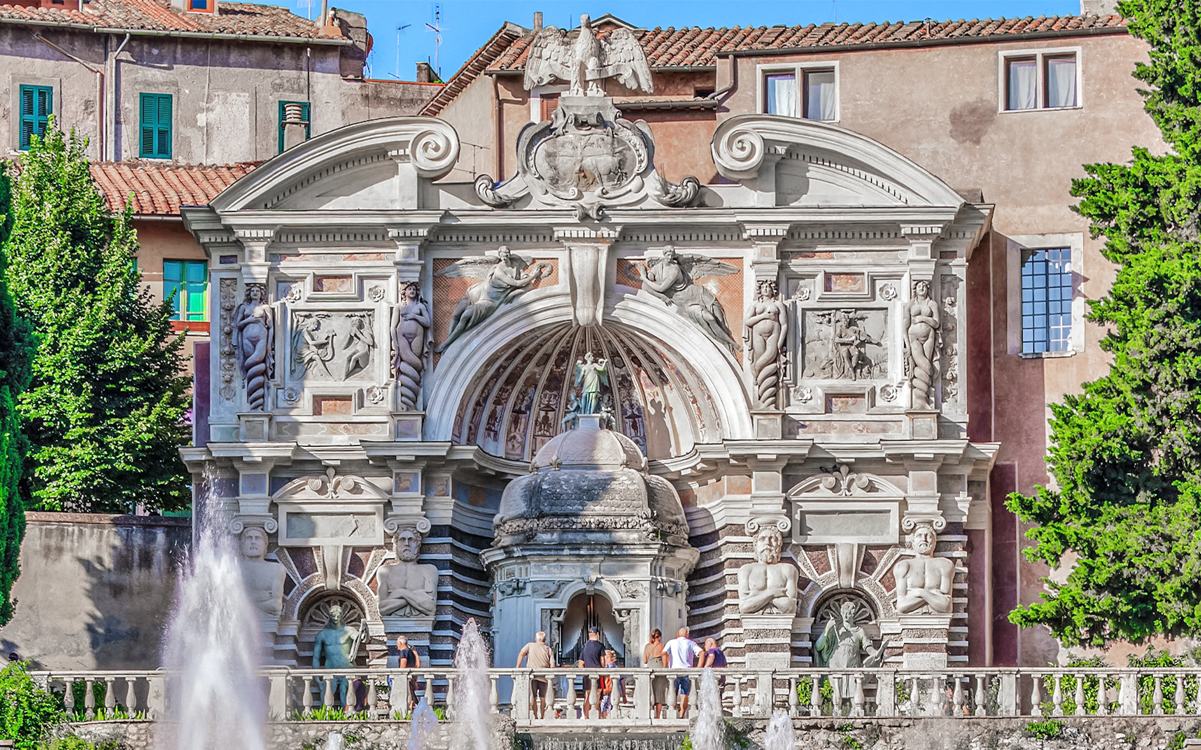 Fountain of Organ at Villa d'Este, Tivoli, with ornate sculptures and visitors exploring.