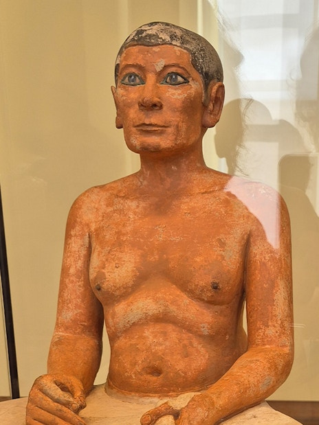Seated Scribe sculpture in the Egyptian Collection at Louvre Museum, Paris.
