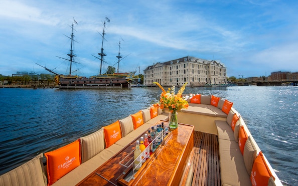 Open boat cruise on Amsterdam canal with view of historic buildings and bridges