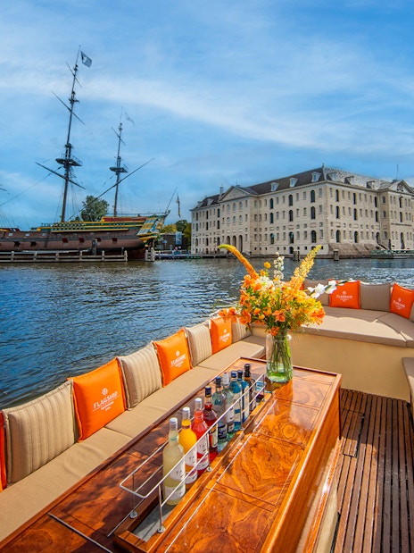 Open boat cruise on Amsterdam canal with view of historic buildings and bridges