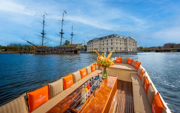 Open boat cruise on Amsterdam canal with view of historic buildings and bridges