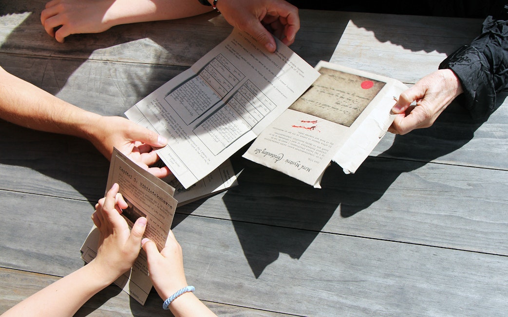 Participants examining mystery hunt clues at Amalienborg Palace.
